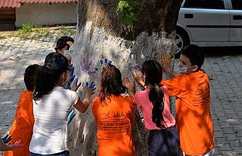 Köy çocukları 150 yıllık ağaçları boyadı