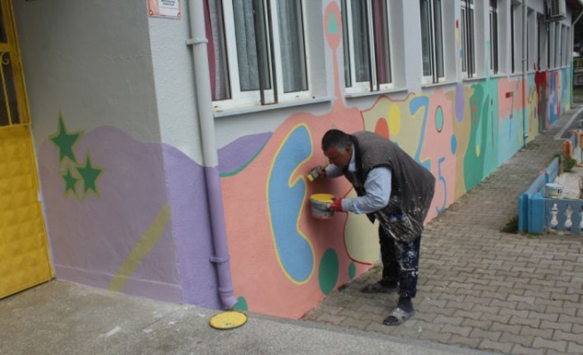 Görme engelli adam eşiyle gönüllü olarak okul duvarlarını renklendiriyor