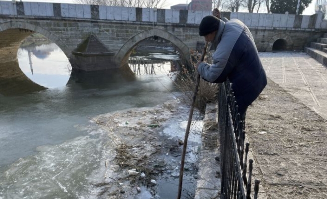 Tunca Nehri'nde buzları kırarak balık tutuyor