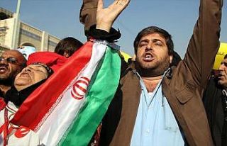 İran'da benzin zammı protestolarında bir kişi...